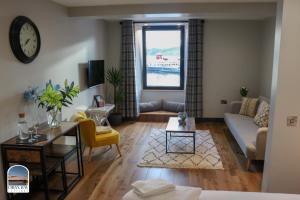 a living room with a couch and a table at Oban Bay Apartments in Oban