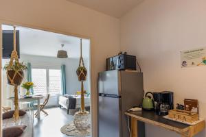 a kitchen with a stainless steel refrigerator with a microwave on top at Studio élément - Eau in Saint-Aignan