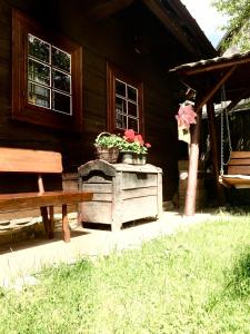 une cabane en bois avec deux plantes en pot et un banc dans l'établissement Dreveničky Holúbkovia, à Terchová