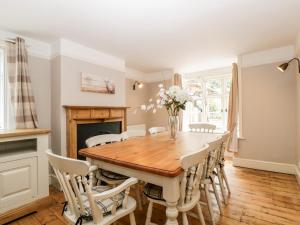 a dining room with a wooden table and chairs at Oakapple Cottage in Lyndhurst