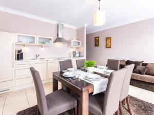 uma sala de jantar e sala de estar com mesa e cadeiras em VacationClub – Zachód Słońca Apartament 22 em Mielno