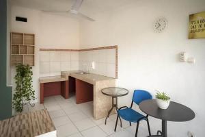 cocina con mesa, 2 sillas y barra en RedDoorz near RS Mitra Keluarga Depok, en Setasiun Depok