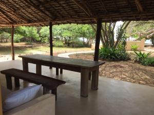 a wooden picnic table and bench under a pavilion at Mangrove House in Lamu