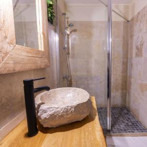 een badkamer met een stenen wastafel en een douche bij Studio élément - Terre in Saint-Aignan