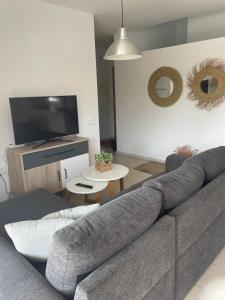 sala de estar con sofá gris y TV en Casa Luna, en Las Negras