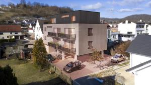 an apartment building with cars parked in front of it at Serviced Apartments - Penthouse im Herzen Königsbronns in Königsbronn