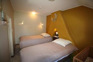 Cette chambre comprend deux lits. dans l'établissement Het Rustplekje, à Alveringem
