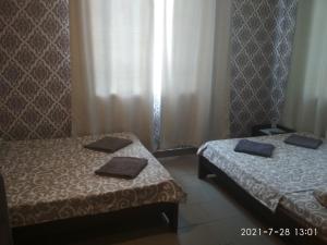 duas camas num pequeno quarto com toalhas em Hotel/Reastaurant Relax em Nova Dofinivka