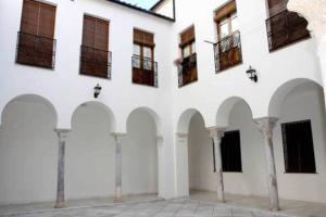 a white building with arches and windows at Penthouse in the Historic District in Córdoba