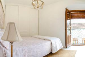 a bedroom with a bed and a lamp and a window at Penthouse in the Historic District in Córdoba