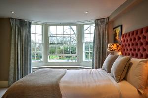 a bedroom with a large bed with a large window at The Horse And Groom Inn in Charlton