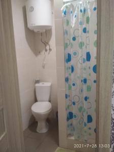 uma casa de banho com um WC e uma cortina de chuveiro em Hotel/Reastaurant Relax em Nova Dofinivka