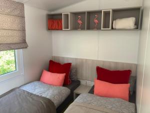 um pequeno quarto com 2 camas e almofadas vermelhas em Rhönstrand em Wartmannsroth