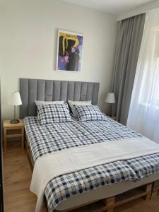 a bedroom with a bed with a blue and white checked blanket at Apartament Podłęska in Kraków