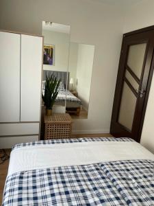 1 dormitorio con 1 cama con una manta azul y blanca a cuadros en Apartament Podłęska, en Cracovia
