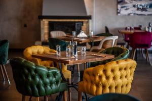 een restaurant met houten tafels en groene stoelen bij Chiflika Family Hotel in Asenovgrad