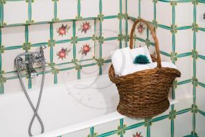 a bathroom with a basket of towels and a sink at Villa Capriccio Sorrento Coast - Capri view villa by the sea in Massa Lubrense