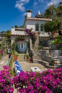a house with purple flowers in front of it at Villa Capriccio Sorrento Coast - Capri view villa by the sea in Massa Lubrense