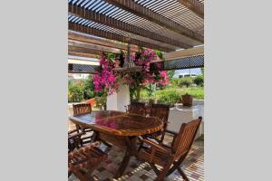 a patio with a wooden table and chairs at A summer house is close to the sea with a garden in Fethiye