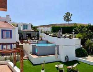 a backyard with a swimming pool and a house at Casas Do Moinho - Turismo De Aldeia in Odeceixe