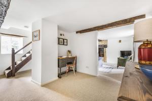 un salon avec un escalier et un bureau dans l'établissement Willow Cottage, à Chilmark