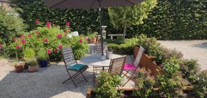 - une table avec des chaises et un parasol dans le jardin dans l'établissement Wetterdelle, à Heers