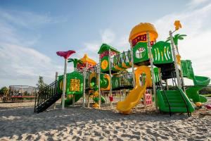 a playground on the beach with a slide at Ross-Domki in Sarbinowo