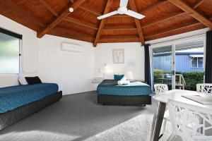 a bedroom with a bed and a window at Wunpalm Motel & Holiday Cabins in Maroochydore
