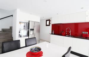 une cuisine avec une table blanche et des placards rouges dans l'établissement Casa el Cielo Spainsunrentals 1184, à El Molino