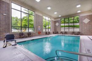 einen großen Pool mit Stühlen und Fenstern in der Unterkunft Comfort Suites Boone - University Area in Boone