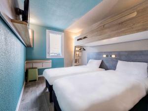 מיטה או מיטות בחדר ב-Ibis Budget Perpignan Sud