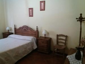una camera da letto con un letto e una sedia di Cortijo "Era Grande 2" a Cordoba
