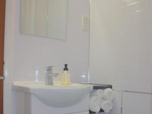 Baño blanco con lavabo y espejo en Ormsgill Inn, en Barrow-in-Furness