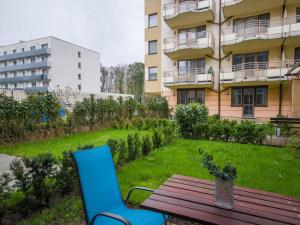 stół piknikowy i dwa krzesła przed budynkiem w obiekcie VacationClub – Zdrojowa 22 Apartament 5 w Świnoujściu
