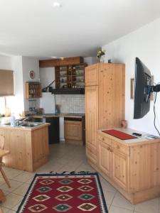 a kitchen with wooden cabinets and a red rug at Schangri-la in Ramsau am Dachstein
