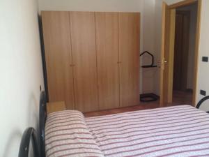 レードロにあるCasa Miravalleのベッドルーム1室(ベッド1台付)、木製キャビネットが備わります。