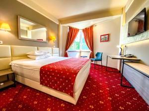 a hotel room with a bed and a red carpet at Best Western Plus Lido Hotel in Timişoara