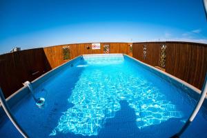 a large blue swimming pool with a wooden fence at Best Lido Hotel in Timişoara