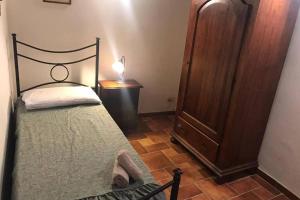 1 dormitorio con 1 cama y vestidor con lámpara en La casa all'Arco, en Campiglia dʼOrcia