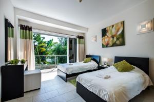 a bedroom with two beds and a large window at Vista Mar by Algarve Villa Holidays in Sesmarias +21 photos