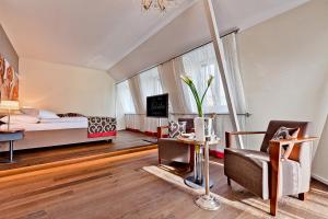 a bedroom with a bed and a living room at Belvédère Strandhotel in Spiez