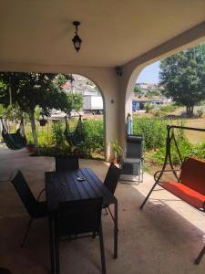 a patio with a table and chairs and a hammock at Apartments Markovi Konaci in Trebinje