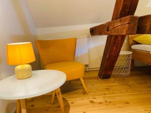 das Höfchen Stadecken في شتادئِكِن إِلسهايْم: كرسي أصفر وطاولة في غرفة مع سرير بطابقين