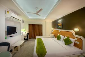 a hotel room with a bed and a tv at Treebo Trend Green View in Kolkata