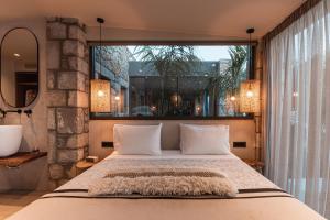 um quarto com uma cama grande e uma janela grande em Bungalows at Almiros Beach em Kalamata