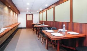 a row of tables and chairs in a restaurant at Treebo Green View in Kolkata
