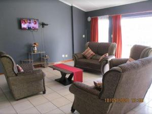 a living room with two couches and a red table at Imimangaliso Guest House in Mthatha