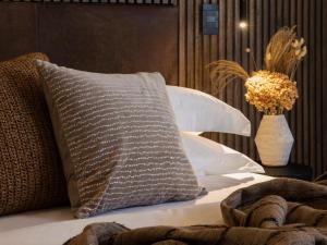 Una cama con una almohada y un jarrón sobre una mesa en Askara Haus en Pretoria