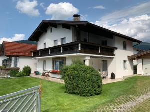 una casa blanca con techo negro y patio en Musi Appartements, en Schönberg im Stubaital