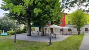 eine Terrasse mit Tischen und Stühlen in einem Park in der Unterkunft Park Hotel Fantoni in Tabiano